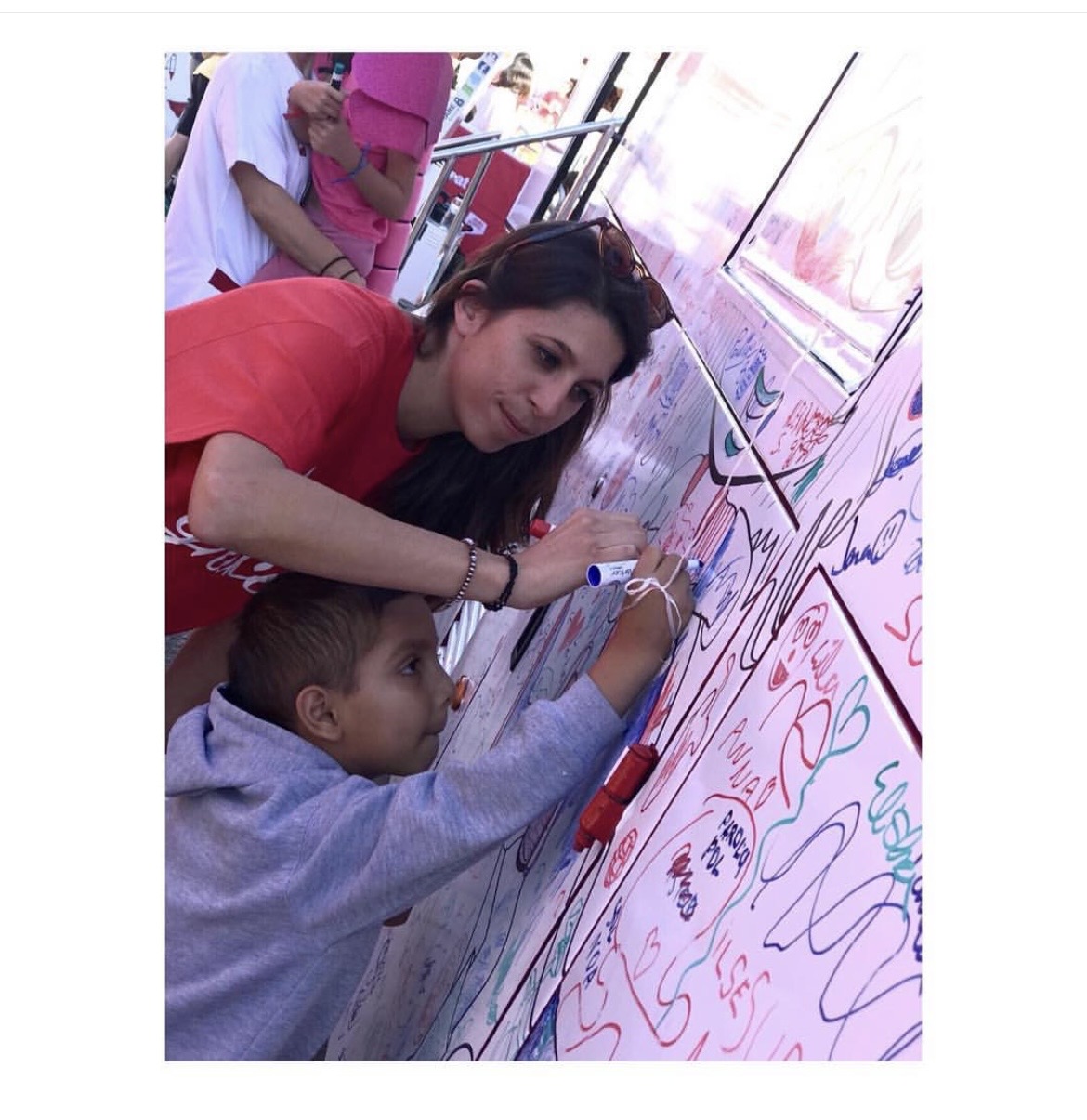 Marta Contreras pintant el bus amb un nen a la Festa dels Súpers