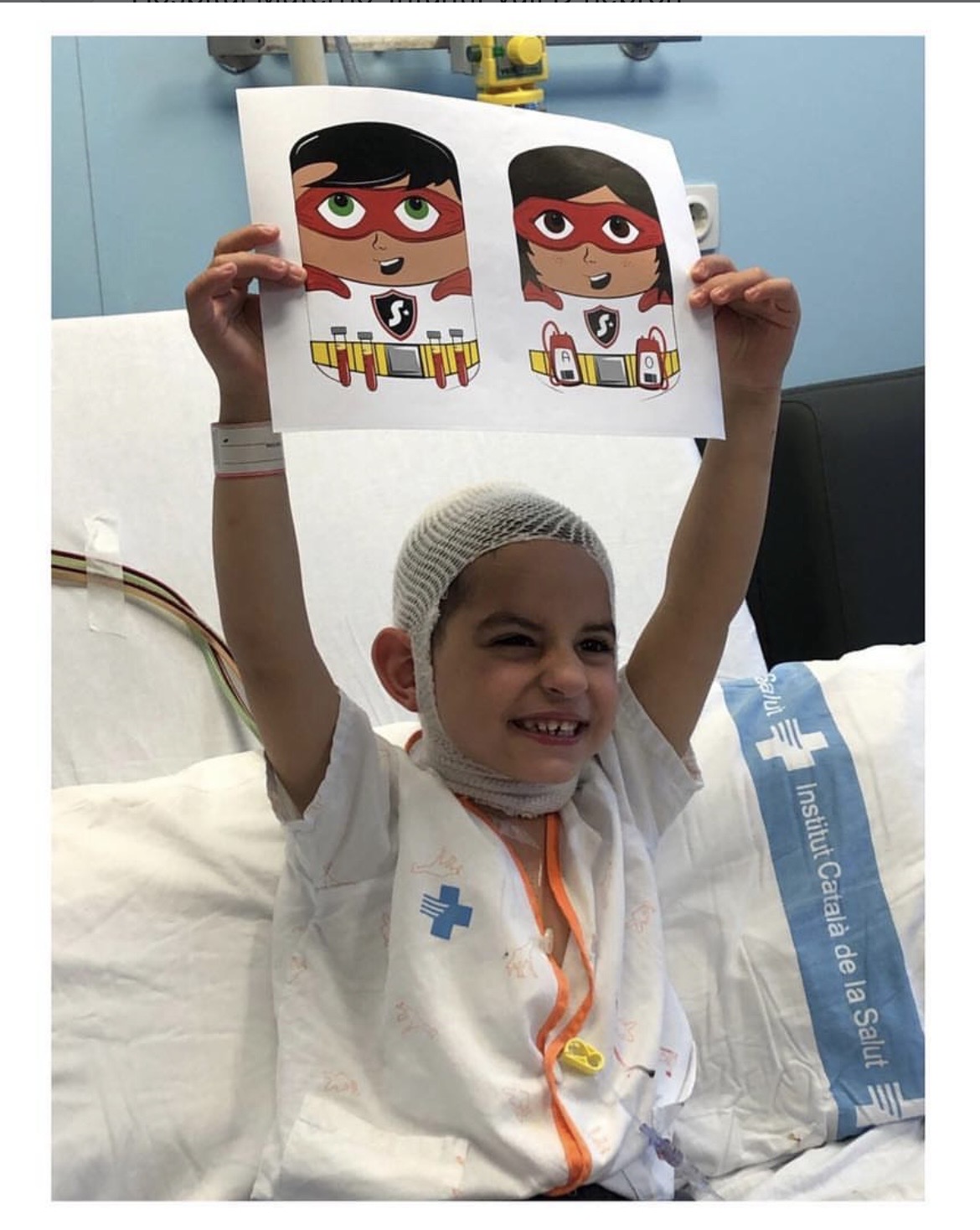 Infant ingressat mostrant les fundes il·lustrades dels Superherois de la Sang
